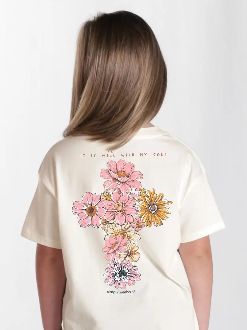 Child wearing a cream Simply Southern T-shirt with floral cross design